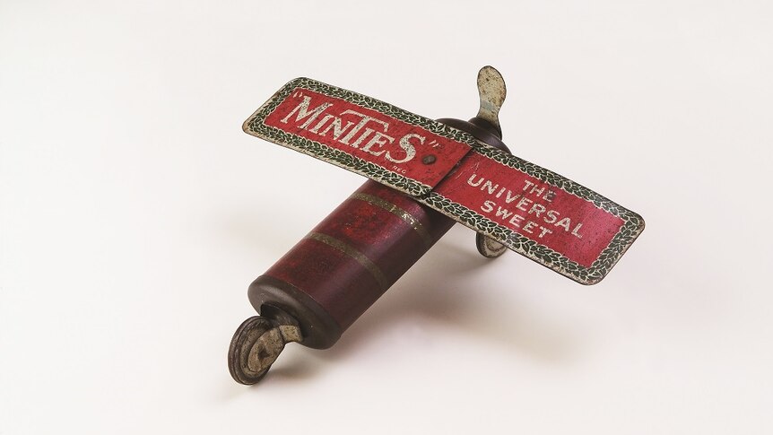 A weathered old toy plane, with MINTIES: THE UNIVERSAL SWEET written across the wings