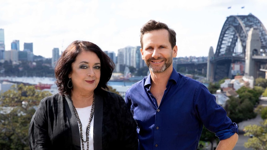 Wendy Harmer and Robbie Buck standing outside with the Sydney Harbour Bridge in the Background.