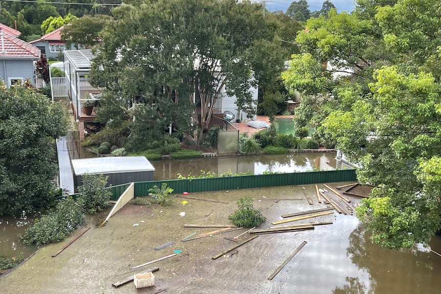 Floodwaters in a suburban back yard.