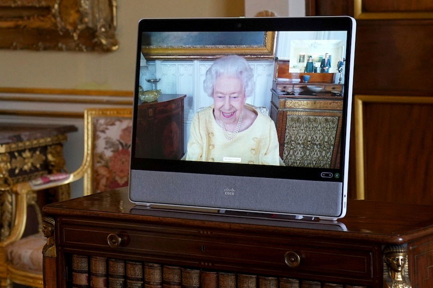 Photo shows the Queen on a tablet smiling on camera 