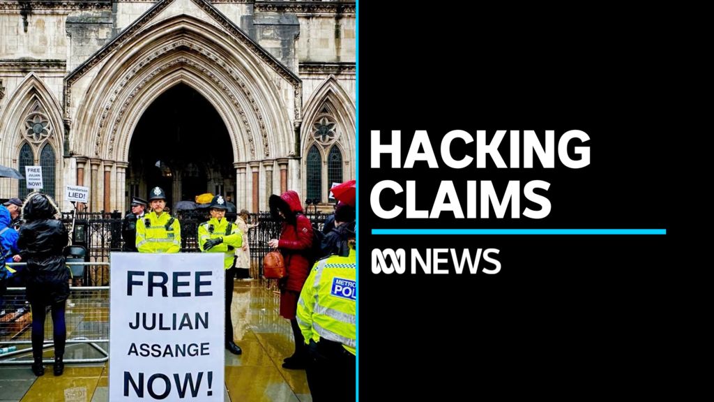 Hacking Claims: Police stand guard behind a pro-Julian Assange sign outside UK High Court