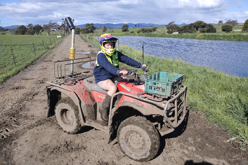 girl on a quad bike with her helmet on