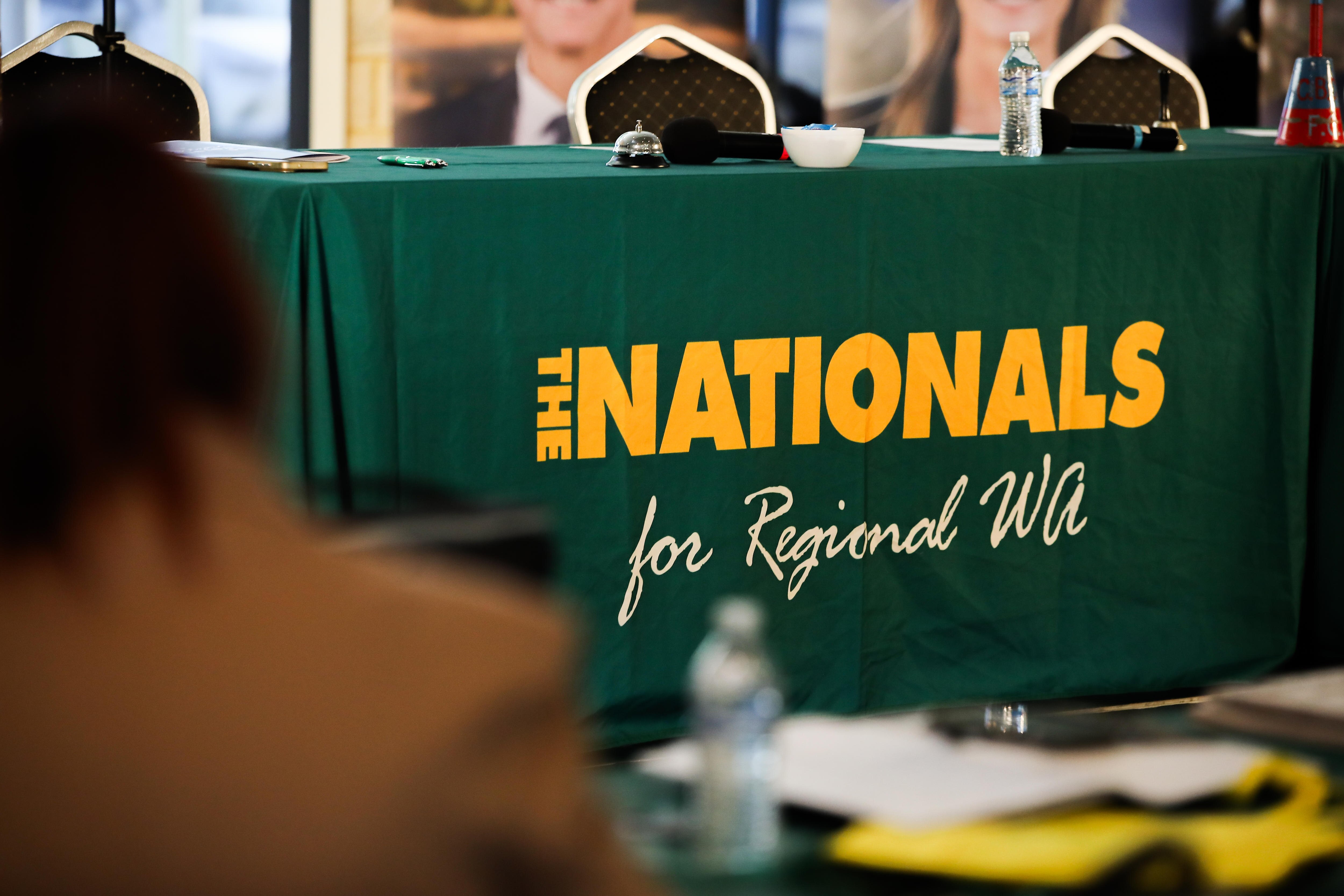 A Green Nationals banner covers a long table at the front of the room