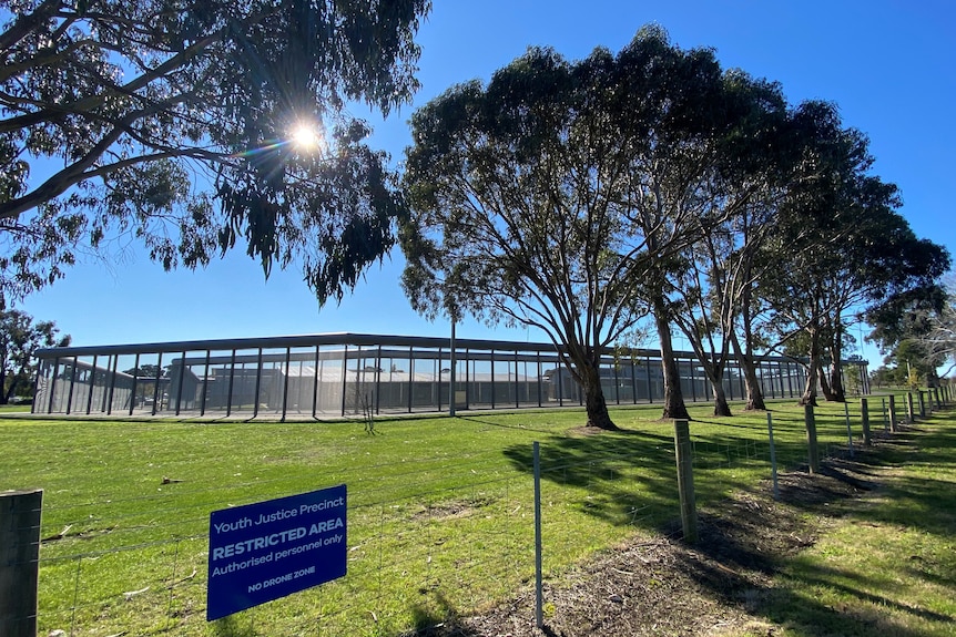 The exterior of a youth detention centre beneath a sunny sky.