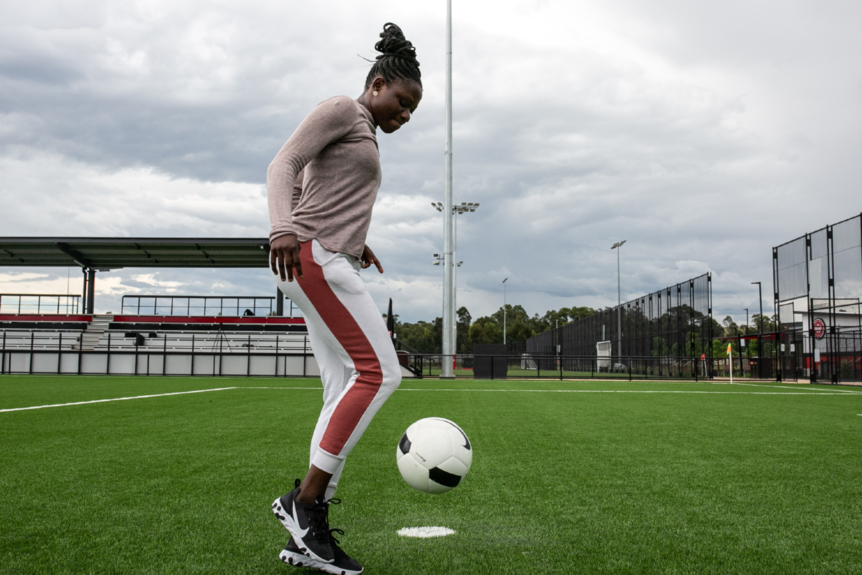 A woman kicks a football