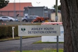 A sign saying 'Ashley Youth Detention Centre' outside some fencing.