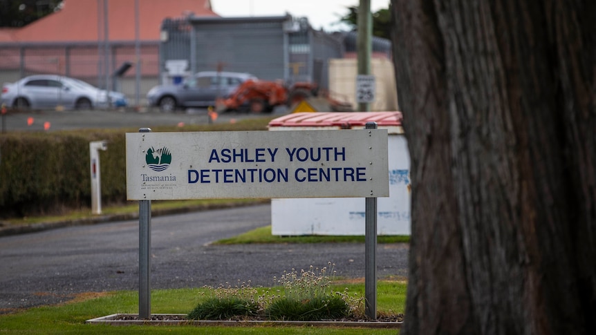 A sign saying 'Ashley Youth Detention Centre' outside some fencing.