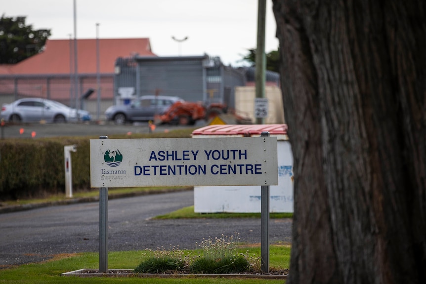 A sign saying 'Ashley Youth Detention Centre' outside some fencing.