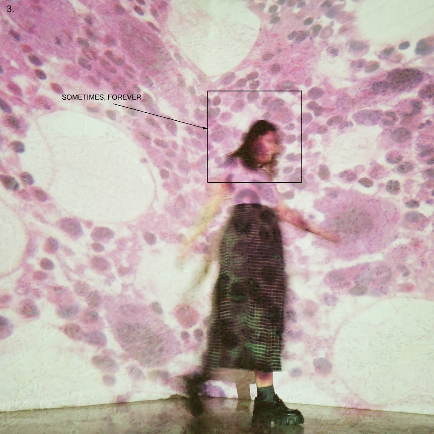 blurred photo of a woman standing in front of purple projected patterns