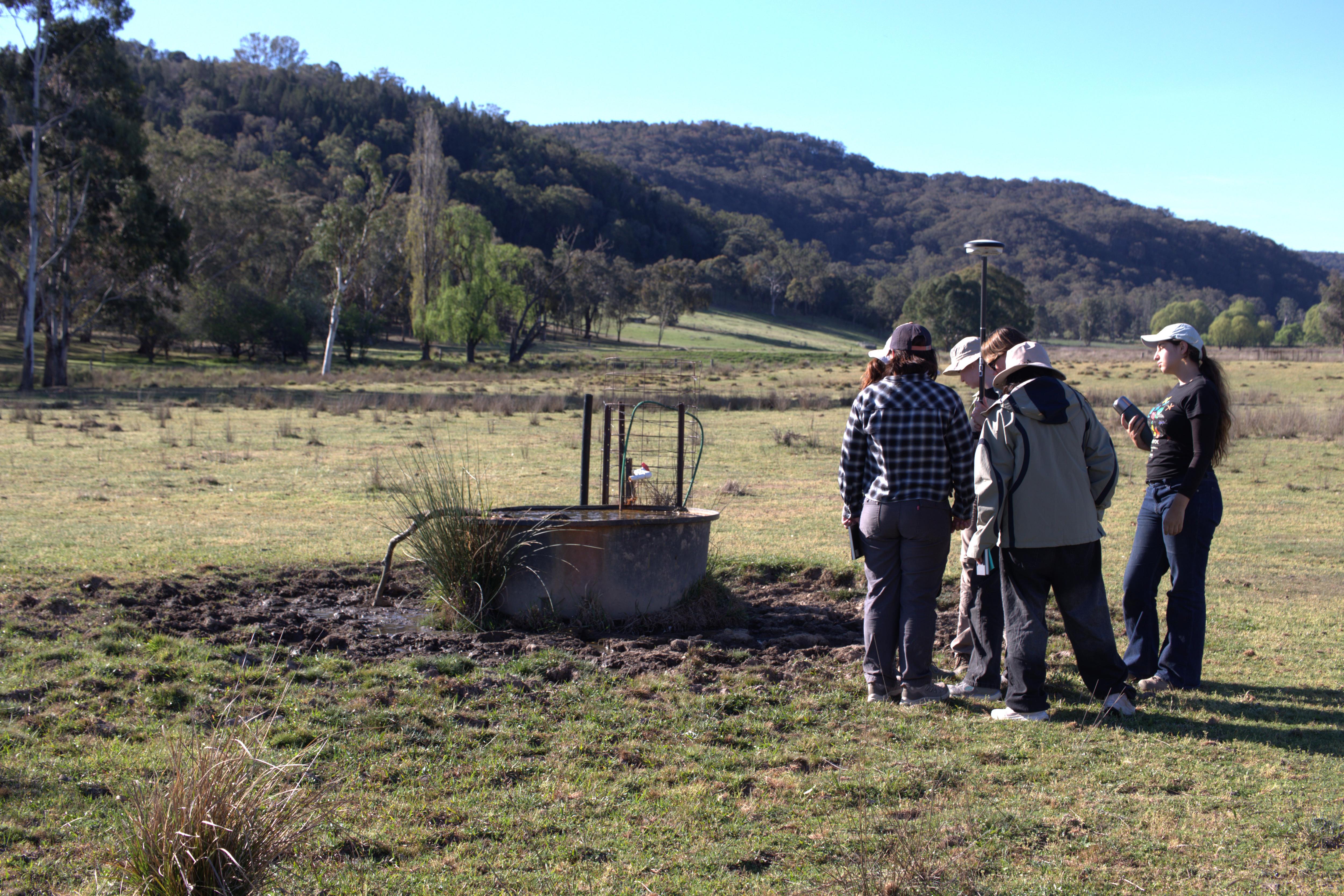 A group of students next to a waterhole