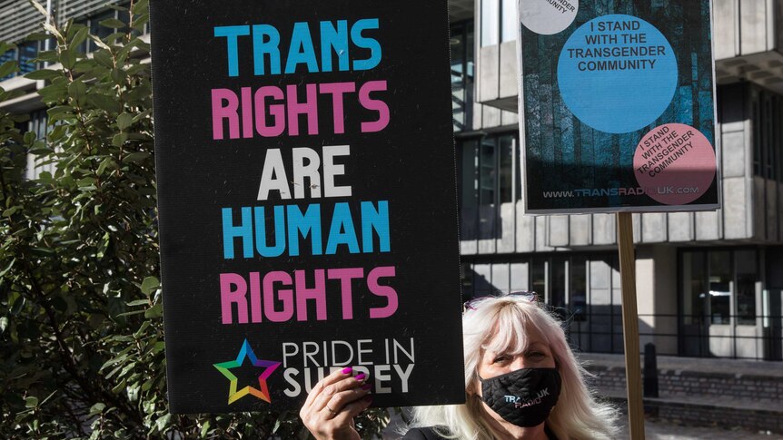 A person holds a sign saying 'Trans rights are human rights'