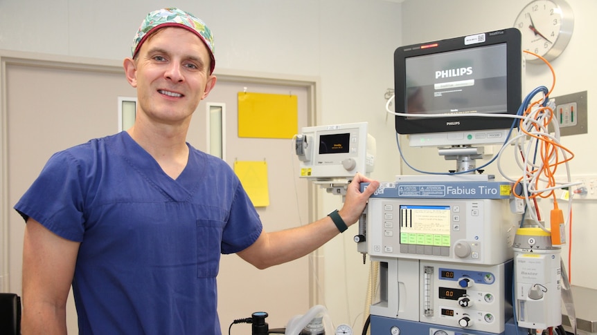 Dr Adam Crossley with the anaesthetic machine he uses to dispense medicine.