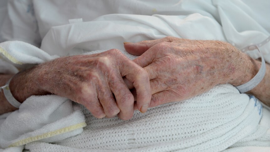 hands of an elderly woman who is lying in hospital