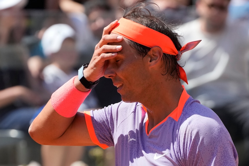 Rafael Nadal puts his right hand to his face during a match at the Italian Open.