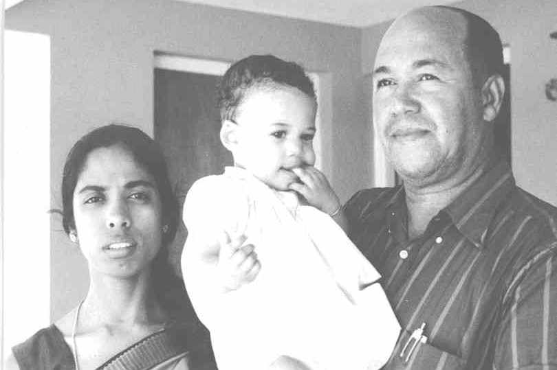 A black and white photo of Kamala Harris as a baby being held by her parents