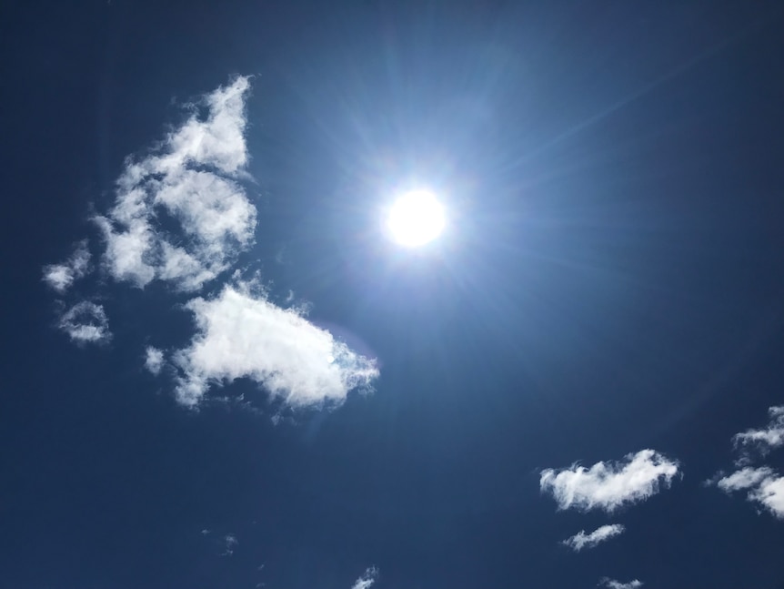 Sun and the clouds, tones of blue and a bright sun