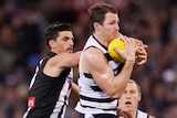 Geelong's Patrick Dangerfield marks a football on his chest ahead of Collingwood's Scott Pendlebury.