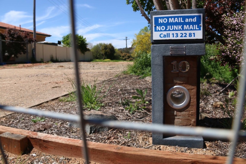 A letterbox sits beside an empty driveway