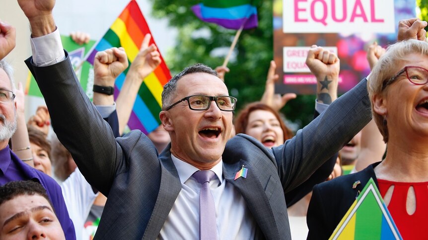 Australian Greens leader Richard Di Natale holds his arms in the air at a 'Yes' rally.