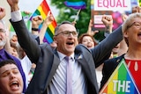 Australian Greens leader Richard Di Natale holds his arms in the air at a 'Yes' rally.