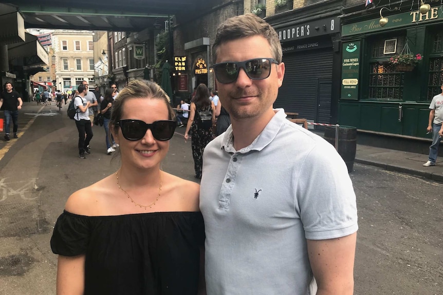 Ashlie and Richard Groves stand next to each other posing for a photo in Borough Market.