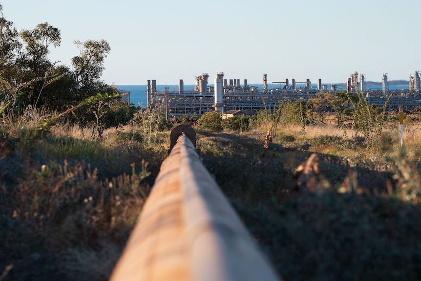 large pipe with gas plant infrastructure in the background