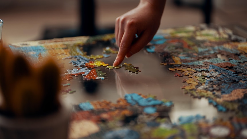 Hand on a jigsaw puzzle