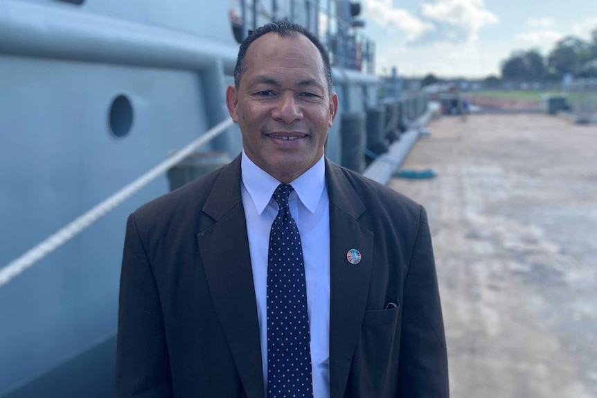SPREP Director General Kosi Latu stands in front of the former New Zealand warship at dock in Newcastle