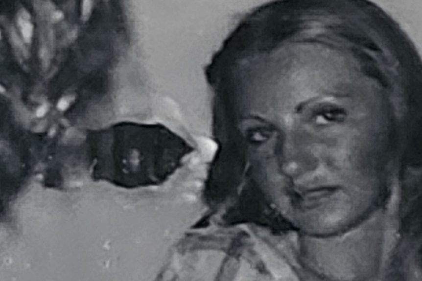 A black and white image of a teenage girl next to a hole in the side of a train