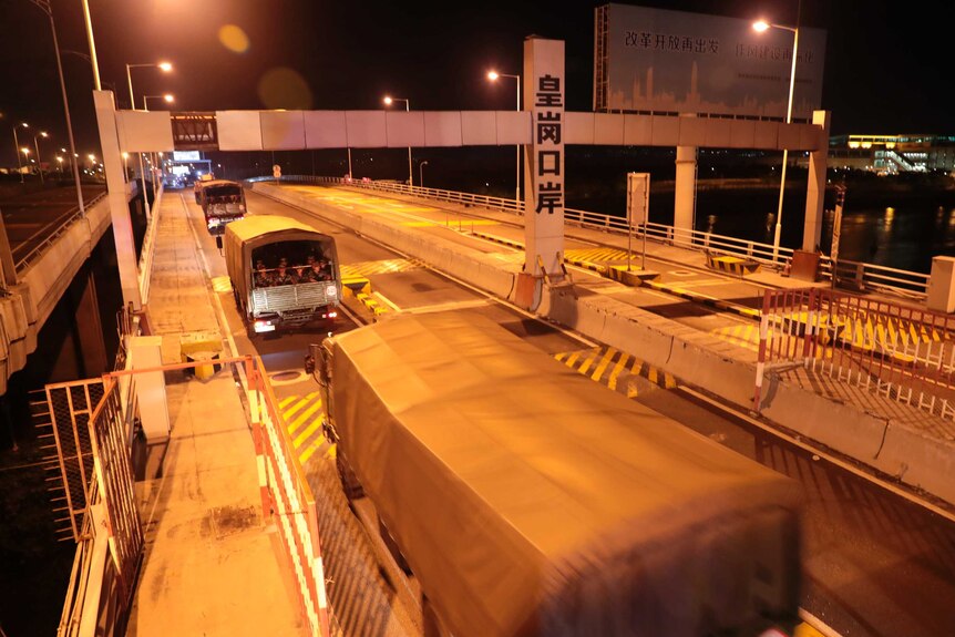 Trucks with Chinese PLA troops in them cross the border to Hong Kong.