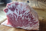 A cut of Brahman hump cut in profile to show the heavy marbling of fat through the meat.