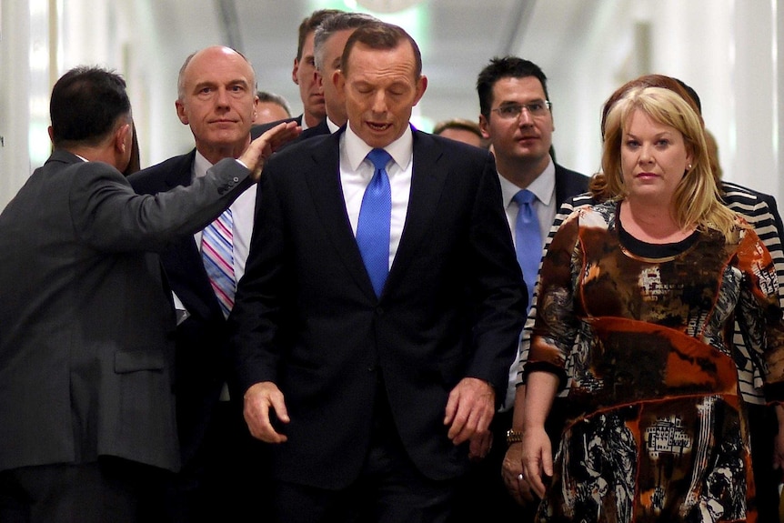 Ousted Prime Minister Tony Abbott receives a pat on the shoulder after losing the Liberal Party leadership.