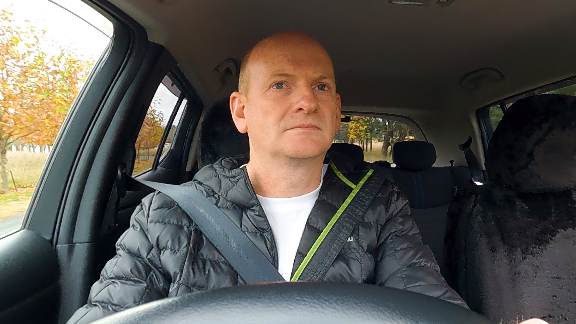 Shane sitting in the driver seat of his car holding the steering wheel