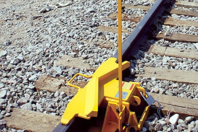 A yellow train derailing device on a track.