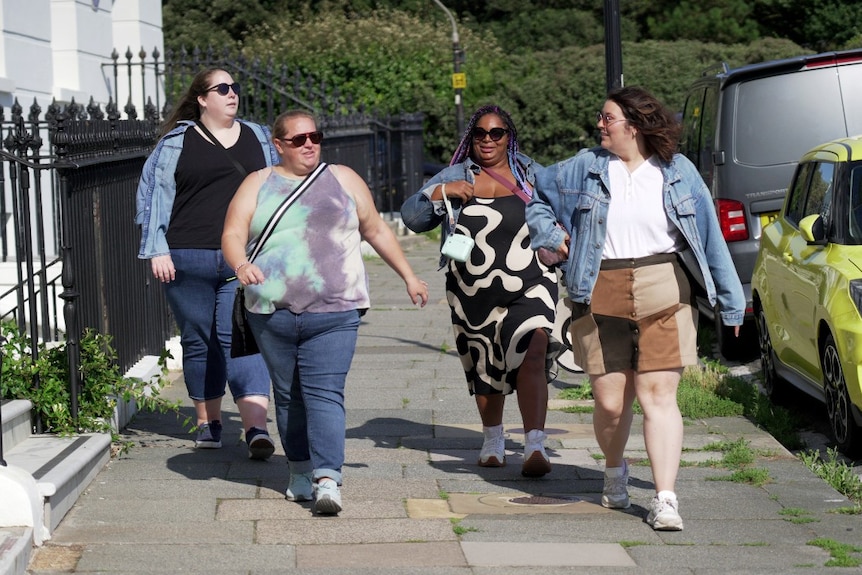 Four women walking and speaking