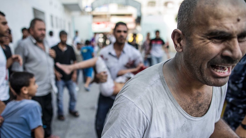 A nine-year-old Palestinian girl is taken to hospital by relatives after she was injured in an Israeli strike in Gaza.