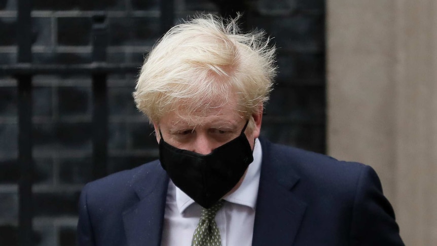 British Prime Minister Boris Johnson wears a black mask outside No. 10 Downing Street.
