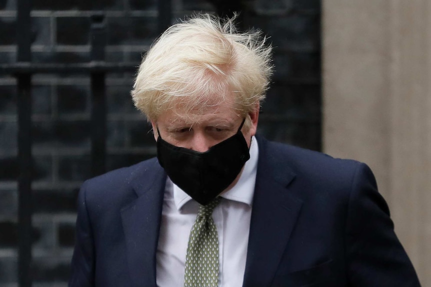 British Prime Minister Boris Johnson wears a black mask outside No. 10 Downing Street.