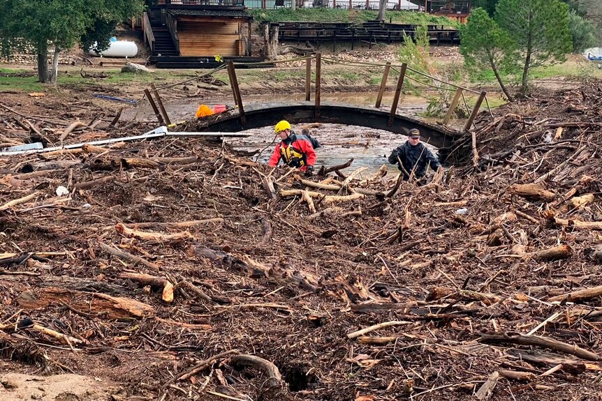 rescuers search through debris after floodwaters swept away a boy in California