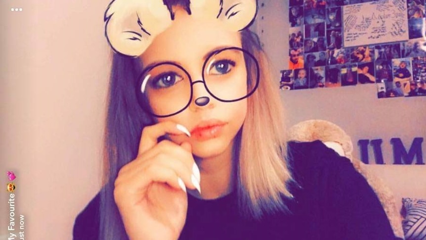 A girl's face with cartoon mouse ears, nose and glasses drawn over it.