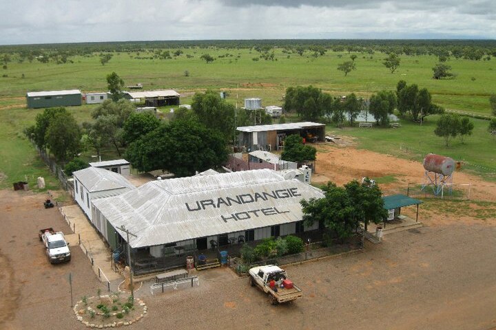 Overhead shot of hotel with tin roof, a few smaller dwellings in the background