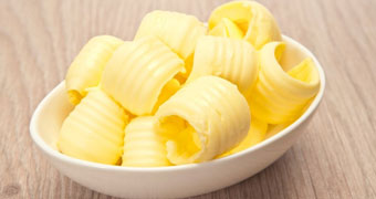 A pile of butter curls sitting in a clear bowl