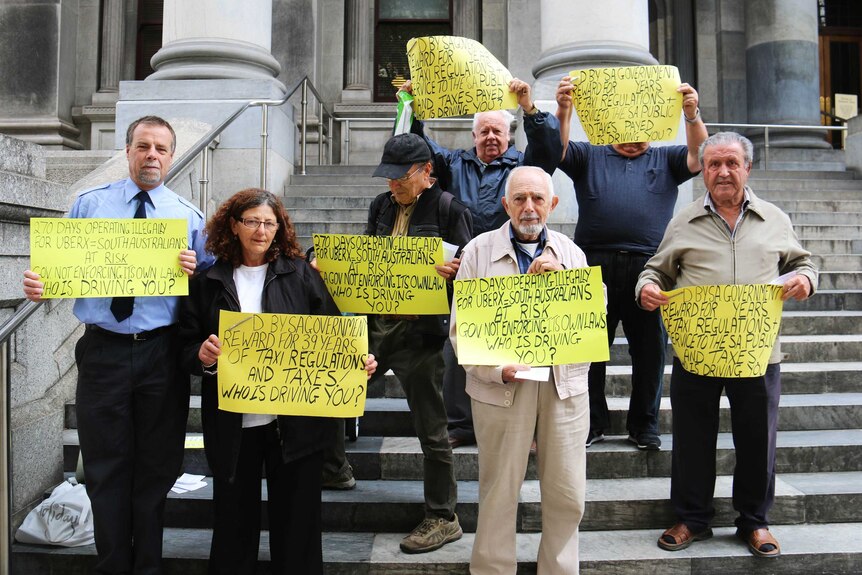 Taxi drivers protest on the steps of Parliament House