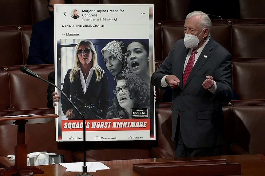 steny hoyer in a suit mimics holding a gun next to an enlarged image of a facebook post from marjorie taylor greene's page