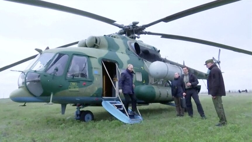 Russian President Vladimir Putin disembarks a helicopter as he visits Kherson.