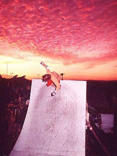 Bob Hastie skating on a ramp at sunset with a beautiful sky behind him.