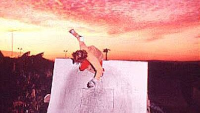 Bob Hastie skating on a ramp at sunset with a beautiful sky behind him.