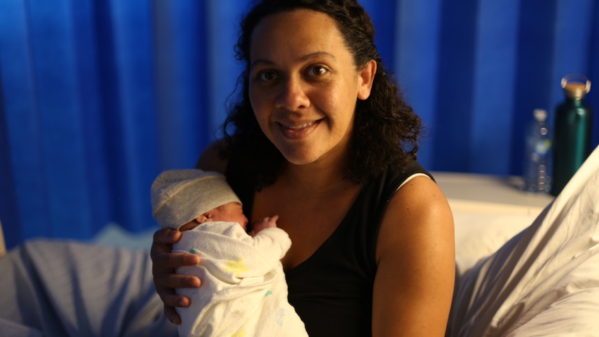 Smiling Priscilla Uhr with newborn baby at Gladstone Hospital