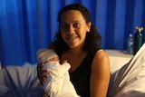 Smiling Priscilla Uhr with newborn baby at Gladstone Hospital