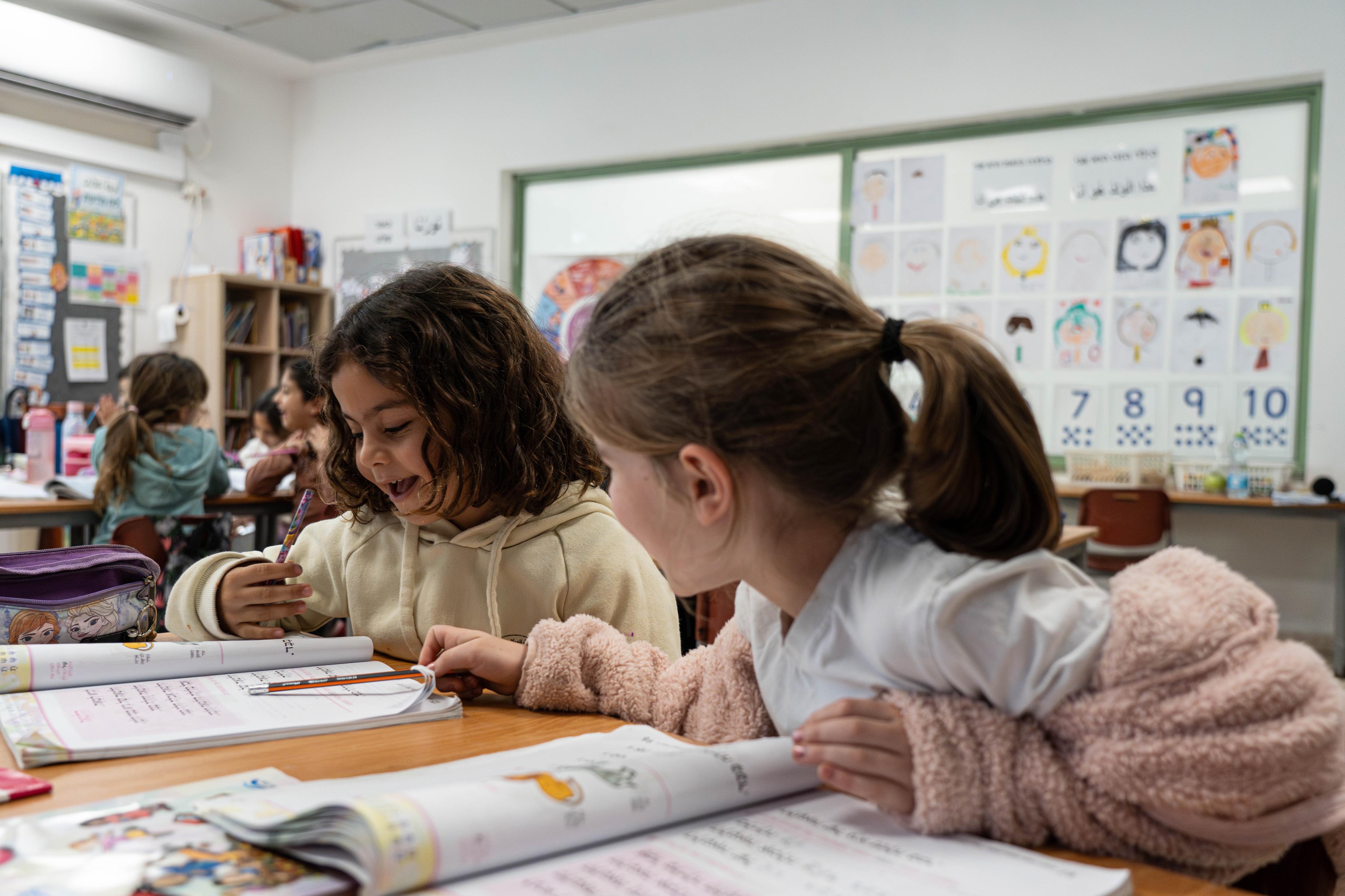 Palestinian and Jewish girls sitting together in a classroom.